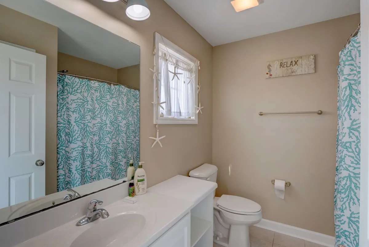 A bright, modern bathroom with a spacious vanity, a shower curtain, and a window letting in natural light. The clean lines and updated fixtures evoke a sense of freshness and renewal.
